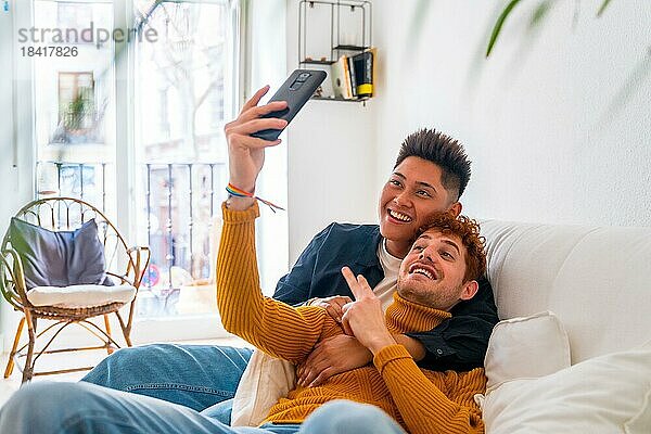 Schöne Homosexuell Paar romantisch zu Hause auf dem Sofa  auf einem Videoanruf  lgbt Konzept
