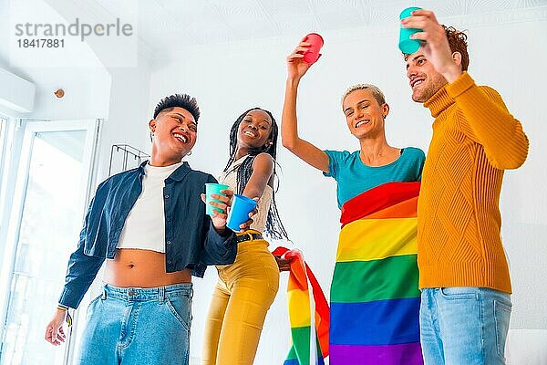 LGBT Stolz  lgbt Regenbogenflagge  Gruppe von Freunden tanzen und stoßen mit Gläsern in einem Haus auf Party