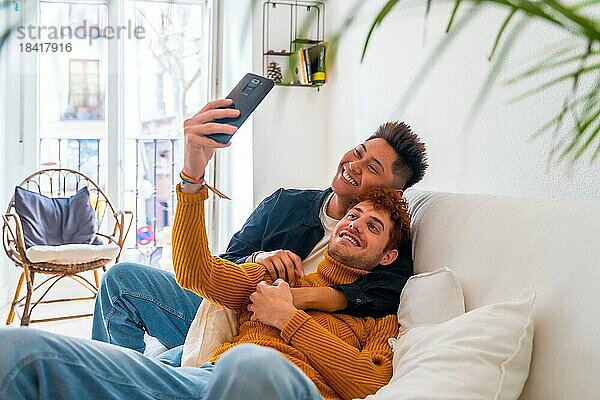 Schönes homosexuelles Paar  das zu Hause auf dem Sofa romantisch ist und ein Selfie macht  lgbt Konzept