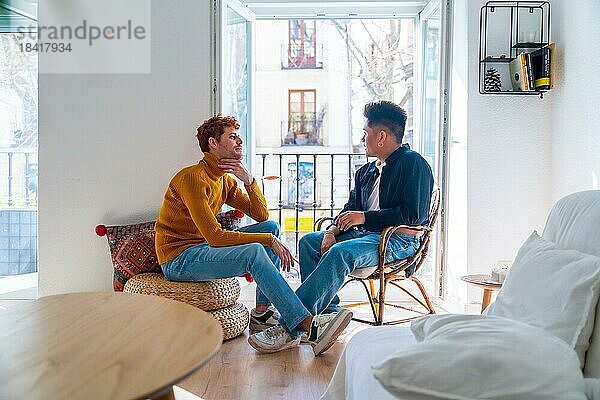 Schöne Homosexuelles Paar romantisch zu Hause auf dem Balkon des Hauses im Gespräch  lgbt Konzept