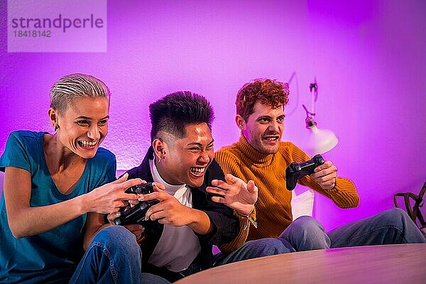 Eine Gruppe junger Freunde  die zusammen auf dem Sofa zu Hause Videospiele spielen  lila gekleidet  mit viel Spaß beim Schieben