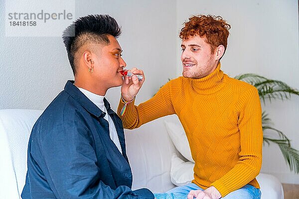 Schöne Homosexuell Paar setzen auf Make up malen ihre Lippen  wobei romantische drinnen zu Hause  lgbt Konzept