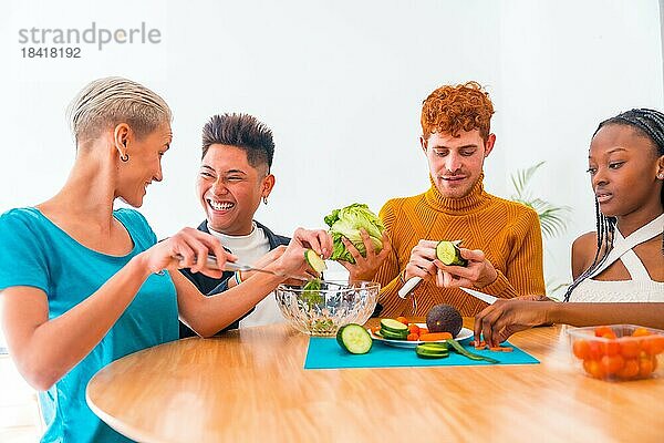 Eine Gruppe von Freunden bereitet einen Salat zu. Sie bereiten Essen zu und haben Spaß in der Küche
