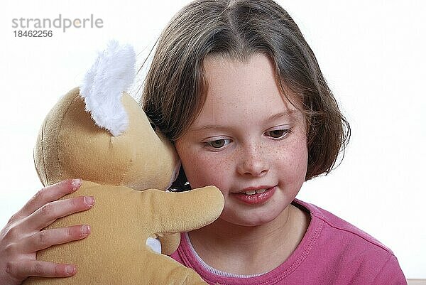 Junges Mädchen kuschelt mit Teddybär