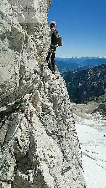 Großzügig ausgesetzte Klettersteigpassage mit herrlichem Blick auf die Bergkette und den Gletscher. Zugspitzmassiv  Bayerische Alpen  Bayerische Alpen  Deutschland  Europa