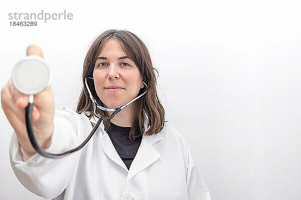 Nahaufnahme Vorderansicht einer jungen Ärztin mit Stethoskop und lächelndem Gesicht vor weißem Hintergrund