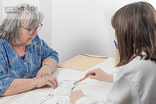 Junge Ärztin  die ihrem Patienten ein Rezept aushändigt