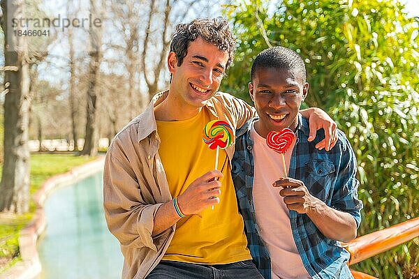 Multiethnisches schwules männliches Paar isst einen Lutscher  lgbt Konzept  romantischer Spaß in der Natur