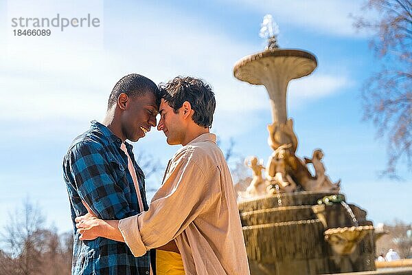 Paar multiethnische Männer in einem Stadtbrunnen  lgbt Konzept  in einer romantischen Pose