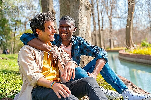 Ein paar multiethnische schwule Männer unterhalten sich leise im Park  lgbt Konzept