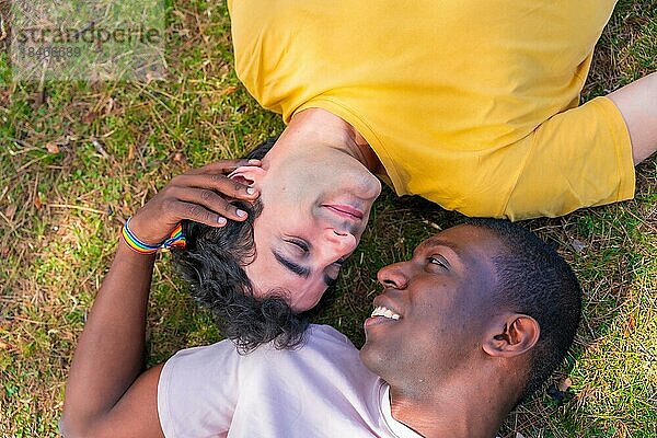 Paar multiethnische Männer in einem Park  lgbt Konzept  liegen auf dem Gras in einer romantischen Pose