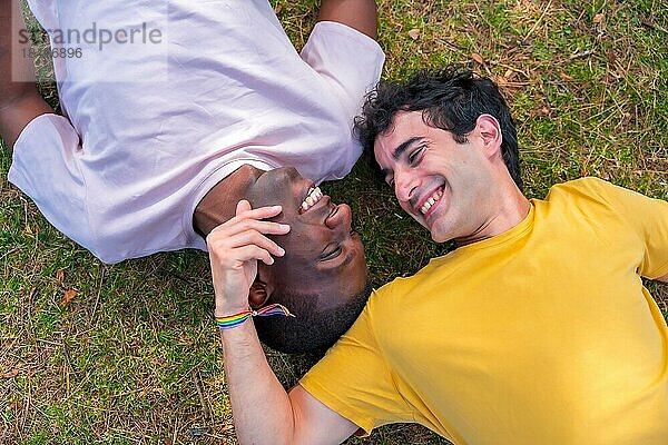 Paar multiethnische Männer in einem Park  lgbt Konzept  liegen auf dem Gras in einer romantischen Pose