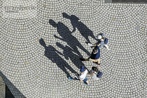 Vier Personen aus der Vogelperspektive  eine Familie geht über einen Platz mit Pflastersteinen  Schatten  Symbolfoto  Stuttgart  Baden-Württemberg  Deutschland  Europa