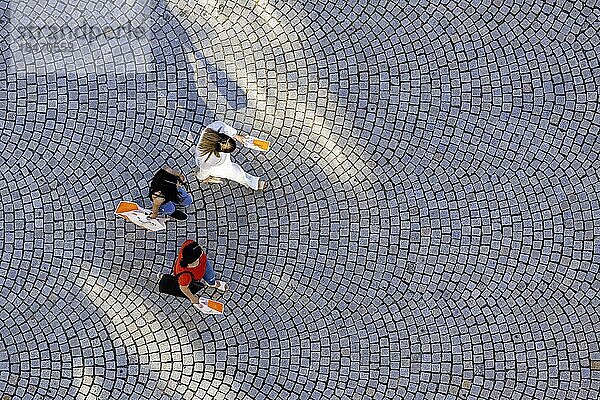 Drei Personen aus der Vogelperspektive  Menschen mit Einkaufstüten gehen über einen Platz mit Pflastersteinen  Symbolfoto  Stuttgart  Baden-Württemberg  Deutschland  Europa