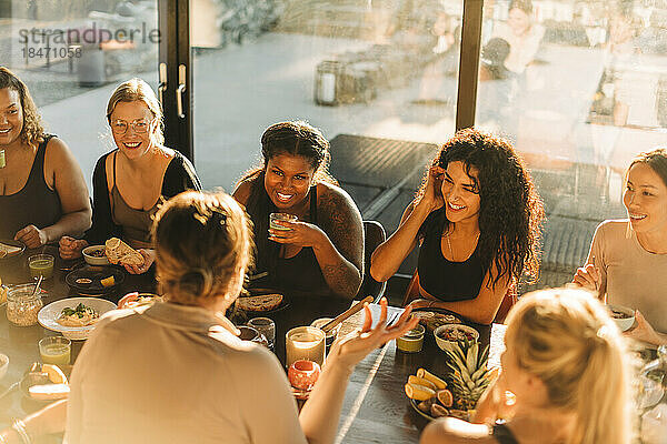 Multirassische Freundinnen  die sich beim Frühstück im Freizeitzentrum unterhalten