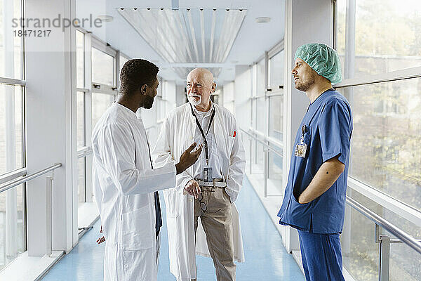 Ärzte und Ärztin diskutieren auf dem Flur eines Krankenhauses
