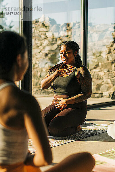 Lächelnde Frau beim Üben von Atemübungen in einer Yogaklasse im Retreat Center