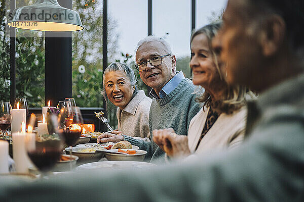 Männliche und weibliche ältere Freunde beim Essen auf einer Dinnerparty