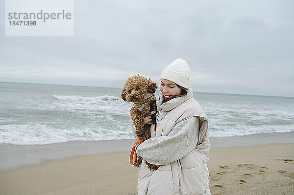 Frau verbringt Urlaub mit Hund am Strand
