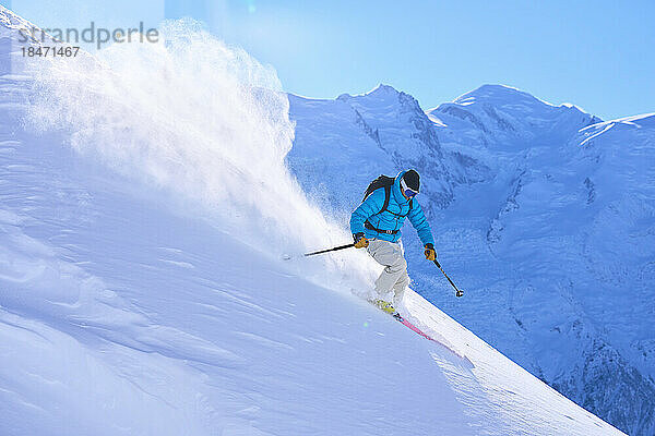 Reifer Mann fährt auf schneebedecktem Berg Ski