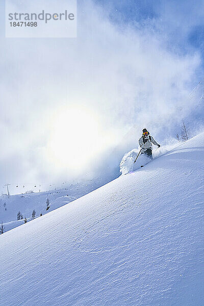 Frau fährt auf schneebedecktem Berg Ski