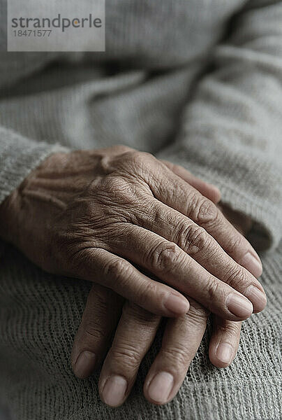 Hände einer älteren Frau auf ihrem Schoß