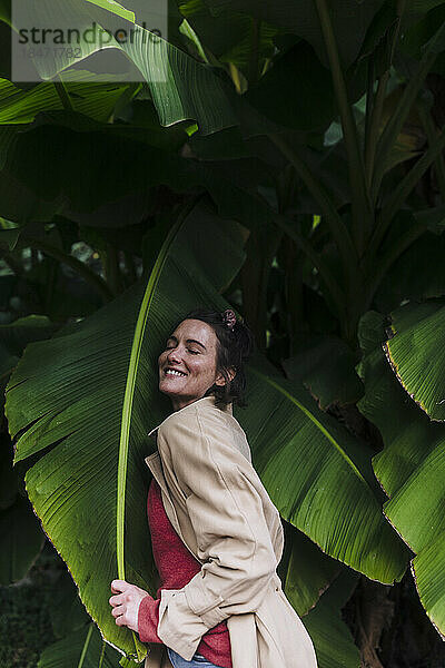 Happy woman embracing banana leaf