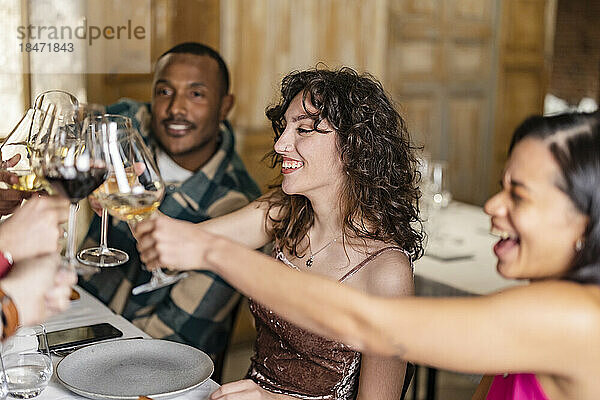Freunde stoßen bei einer Dinnerparty im Restaurant mit Weingläsern an