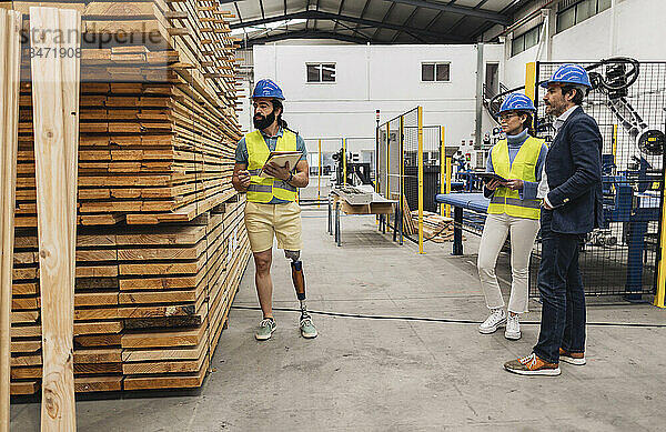 Ingenieur untersucht Bretterstapel mit Kollegen in der Fabrik