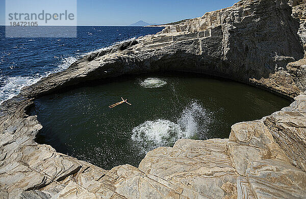 Frau schwimmt an sonnigem Tag im Höhlenbecken
