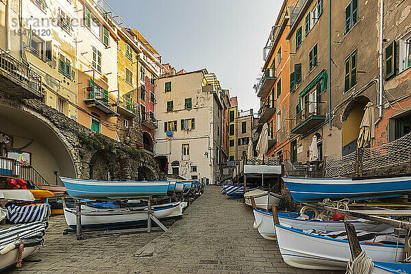Italien  Ligurien  Riomaggiore  Boote liegen entlang einer leeren Straße einer Küstenstadt entlang der Cinque Terre