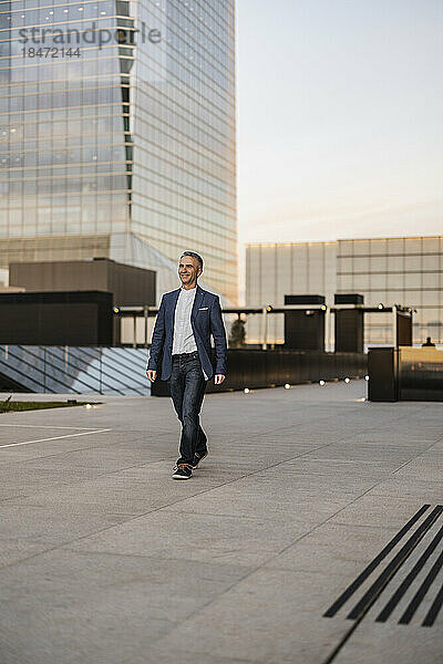 Mature businessman walking in office park