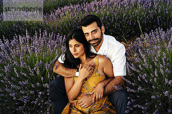 Young woman sitting with man in lavender field