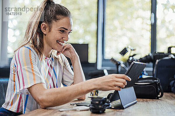 Lächelnde Geschäftsfrau benutzt Tablet-PC am Schreibtisch