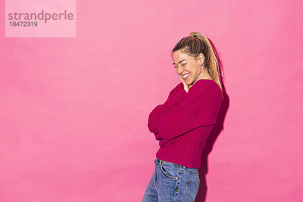 Happy woman against pink background