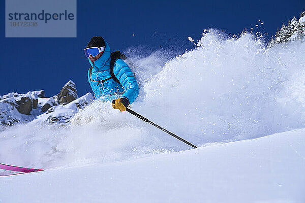 Mann mit Skibrille fährt im Schnee Ski