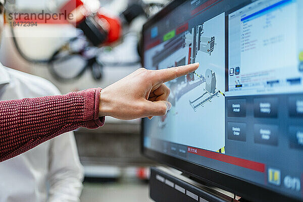 Hand des Ingenieurs zeigt auf Computerbildschirm in der Industrie