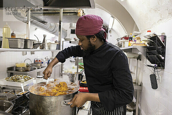 Koch rührt Essen in der Küche im Restaurant um