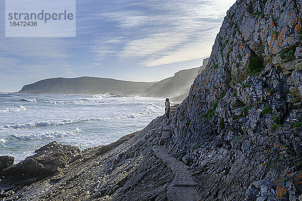 South Africa  Eastern Cape  Male hiker on narrow coastal boardwalk in Plettenberg Bay