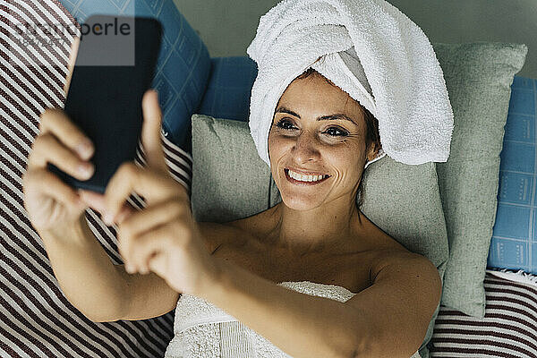 Glückliche Frau  die zu Hause ein Selfie mit dem Smartphone macht