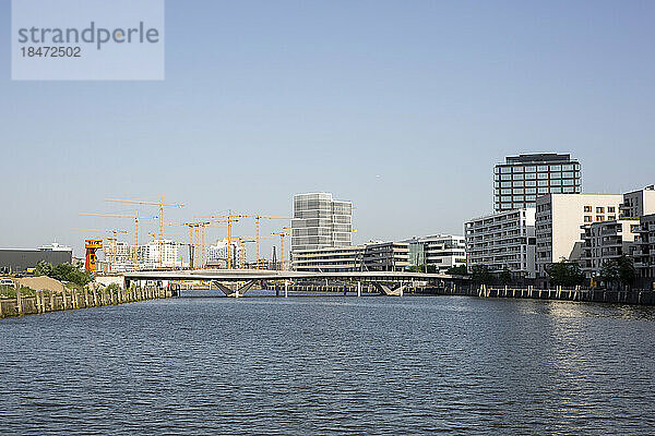 Deutschland  Hamburg  Elbe fließt durch die HafenCity mit Brücke und großer Baustelle im Hintergrund