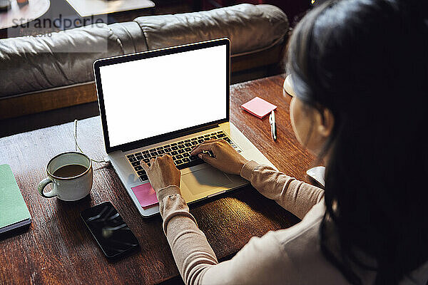 Geschäftsfrau arbeitet am Laptop am Schreibtisch im Loft-Büro
