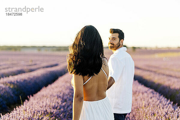 Frau geht mit Mann im Lavendelfeld spazieren