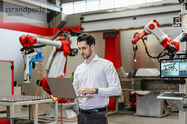 Ingenieur benutzt Laptop in Roboterfabrik