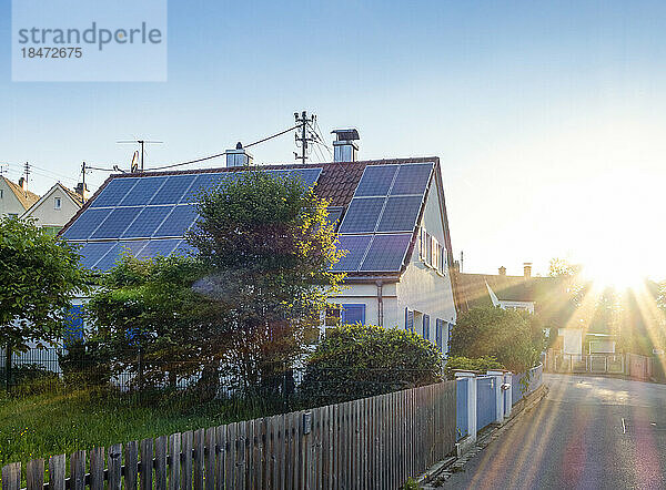Solar panels on roof of house at sunset
