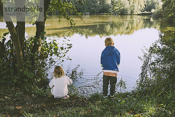 Jungen und Mädchen spielen in der Nähe des Sees