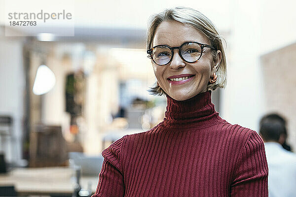 Glückliche Geschäftsfrau mit Brille im Büro