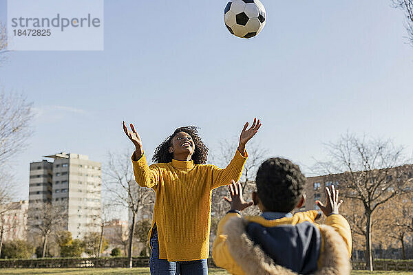 Verspielte Mutter und Sohn fangen Ball im Park