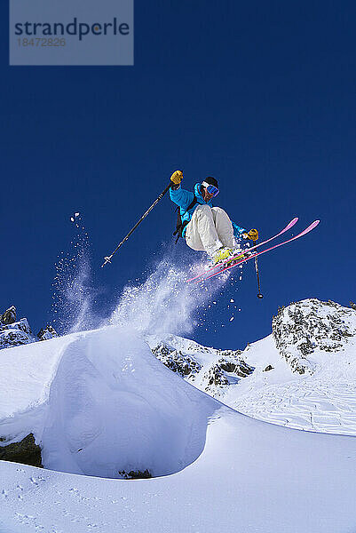 Skifahrer springt vom Schnee am Berg
