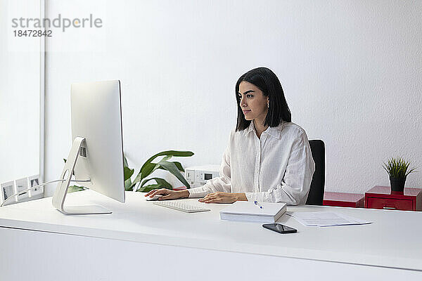 Geschäftsfrau arbeitet am Schreibtisch am Desktop-PC